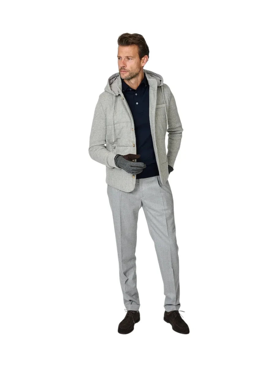Heren mode: grijze hoodie met capuchon, donkerblauwe polo en lichtgrijze pantalon.