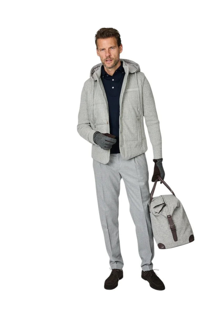Man in grijze hoodie, donkerblauwe polo en grijze pantalon met reistas.