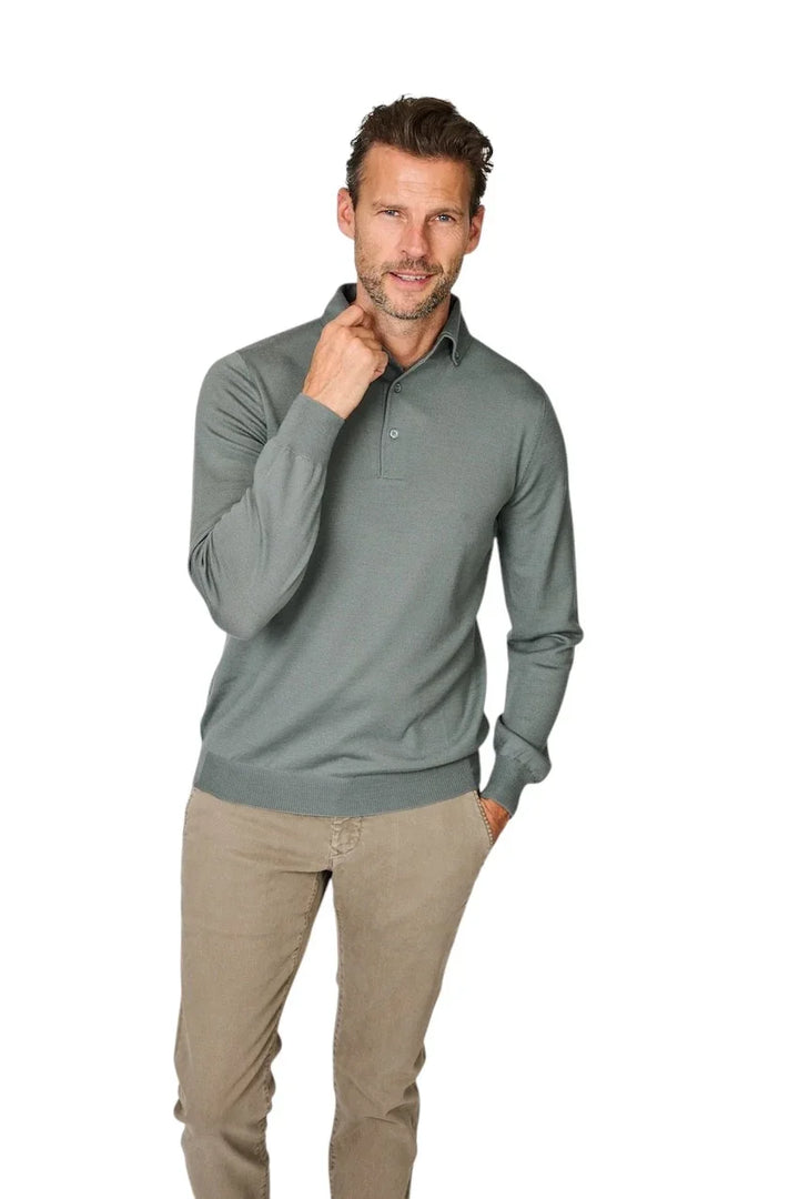 Man in een grijsgekleurde polo met lange mouwen en beige chino broek