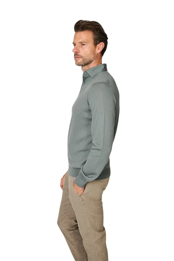 Man in een lichtgroene poloshirt met lange mouwen en beige broek