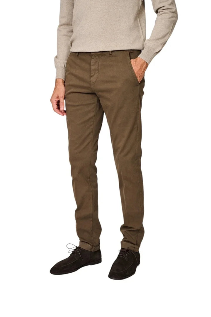 Man in een beige trui, bruine chino broek en donkerbruine suède schoenen