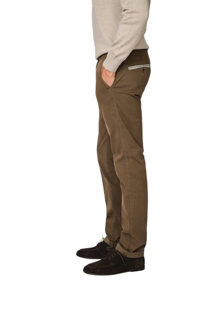 Man in een bruine chino broek met ritszak en donkerbruine suède schoenen