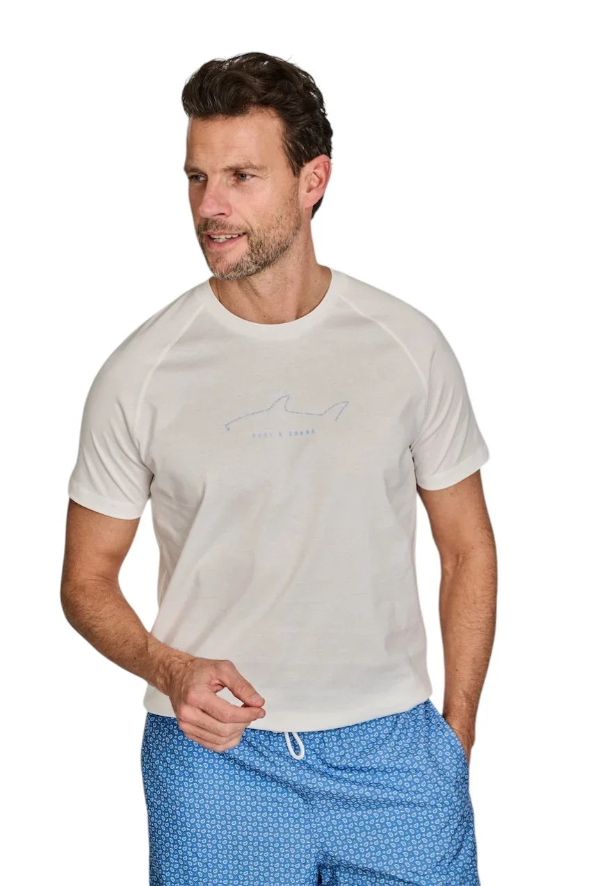 Man in witte Paul & Shark t-shirt en blauwe geprinte zwembroek